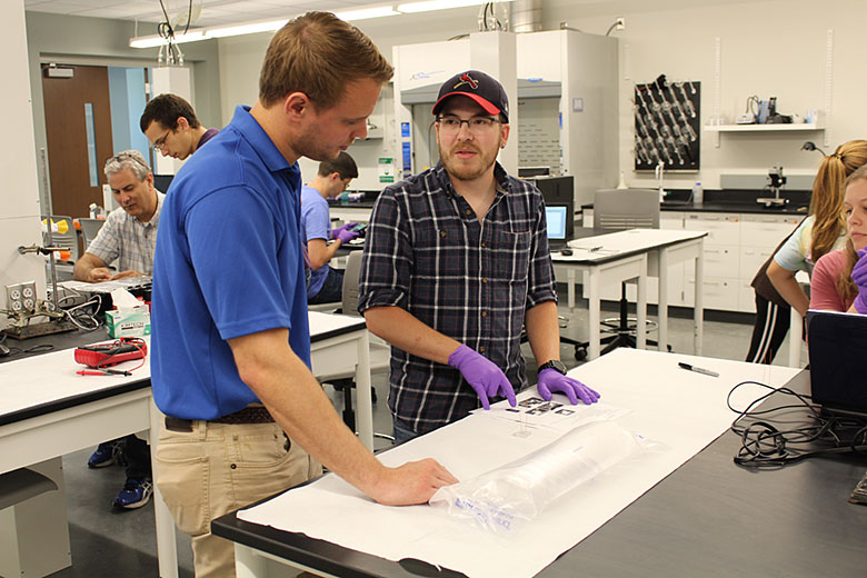Jay Sibbits (right) explains the laboratory procedures to Grahmm Funk (left)