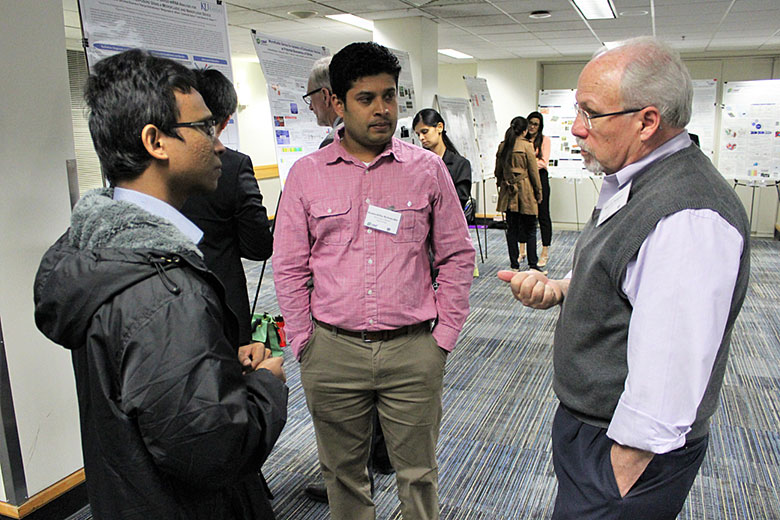 Prof. Steve Soper talks with graduate student Thilanga Pahattuge (left) and Dr. Kumuditha Ratnayake (right) at the poster session