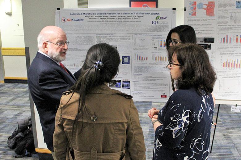 Dr. David Kaufman interacts with three authors of the poster, Mengjia Hu, Maggie Witek, and Sachindra Gamage