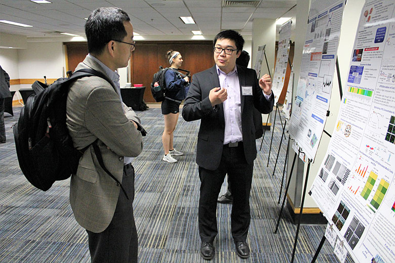Graduate student Zheng Zhao (right) presents his poster to Dr. Sunggook Park (right)