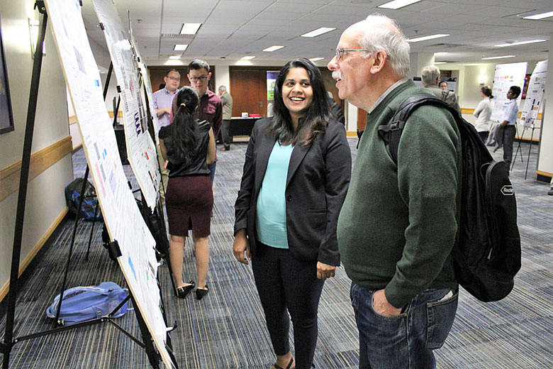 EAB member Dr. Bill Efcavitch enjoys a moment listening to graduate student Charuni Amarasekara's poster presentation