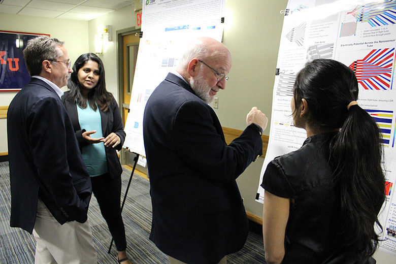 Dr. David Kaufman interacts with Swarnagowri Vaidyanathan (foreground) while Charuni Amarasekara discusses her project with Dr. Andrew Godwin