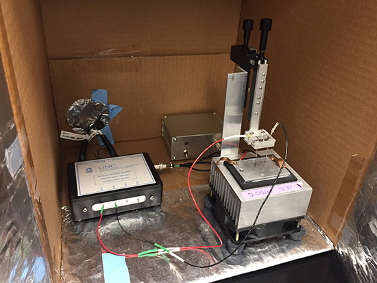 A patch clamp setup with amplifiers, a cooling unit, and a micromanipulator inside an insulated box.
