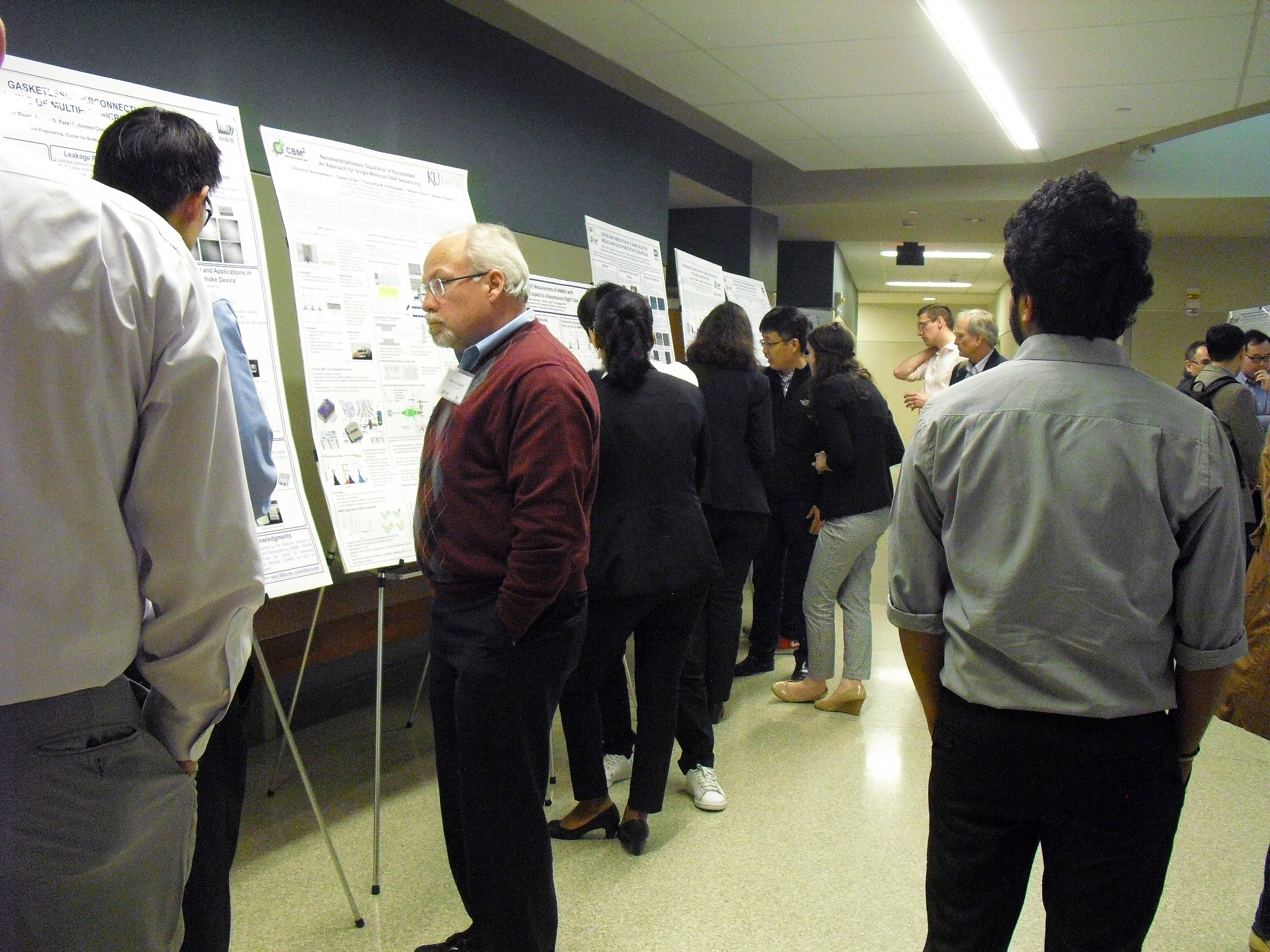 Individual presenting key points on a research poster to Dr. Soper in a focused discussion.