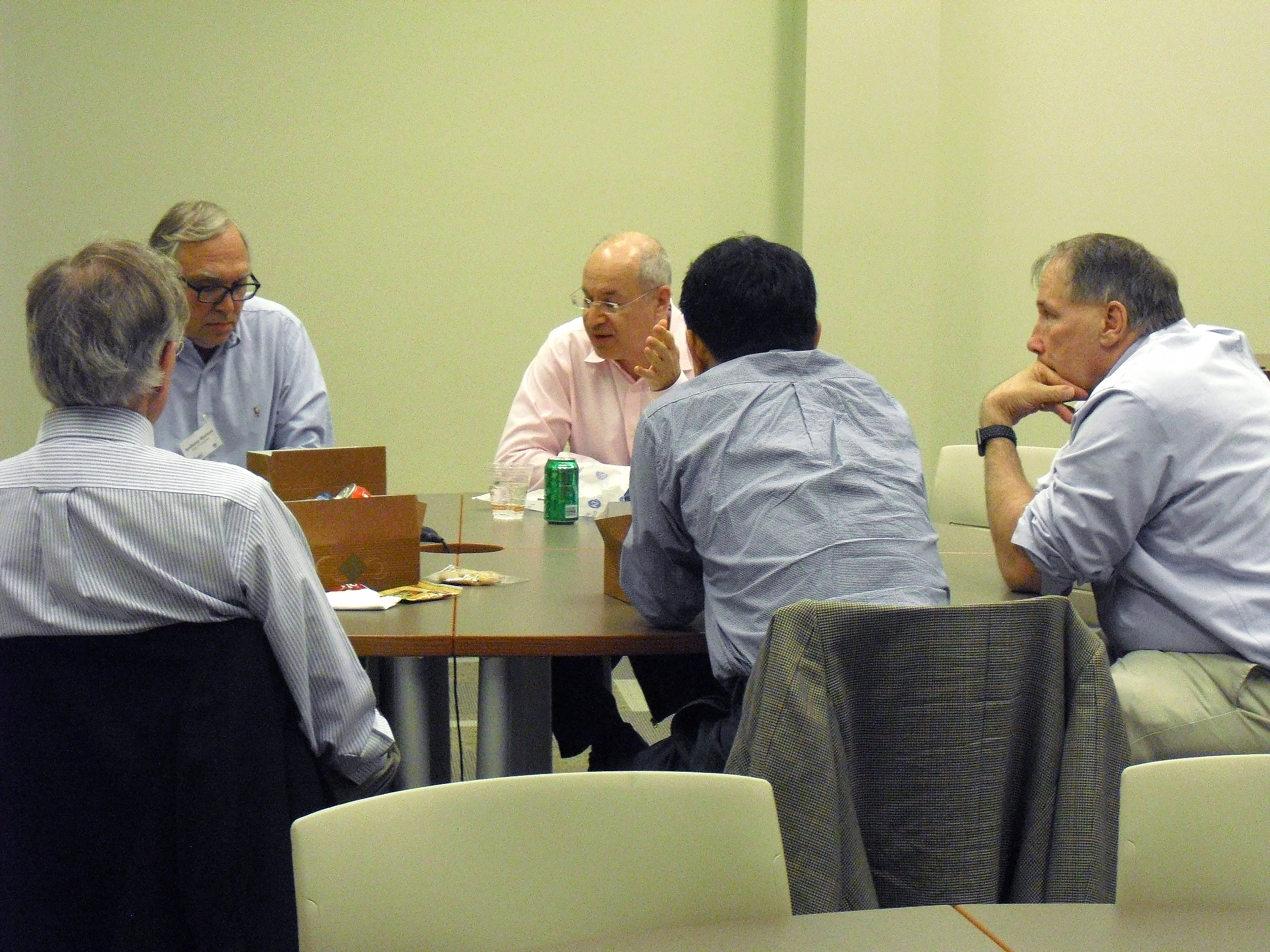 Five individuals seated around a table engaged in conversation, including Dr. Soper.
