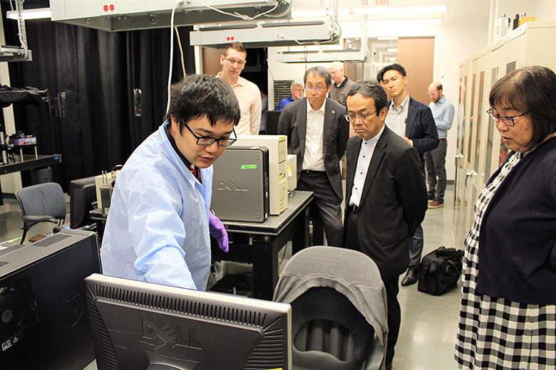 Zheng Zhao, graduate student in the Soper lab, presents his project to visitors from Shimadzu Corporation